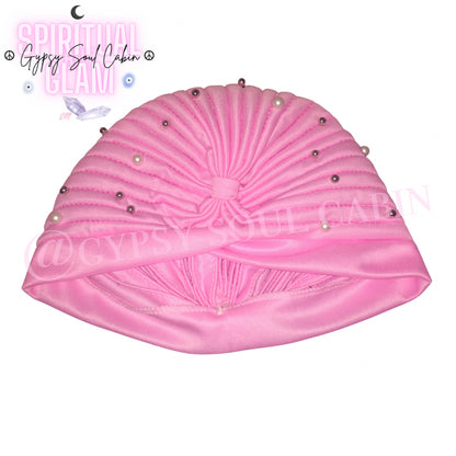 Close-up of a pink satin bohemian gypsy head wrap adorned with pearl beads, showcasing its gathered, ruched design and decorative details.