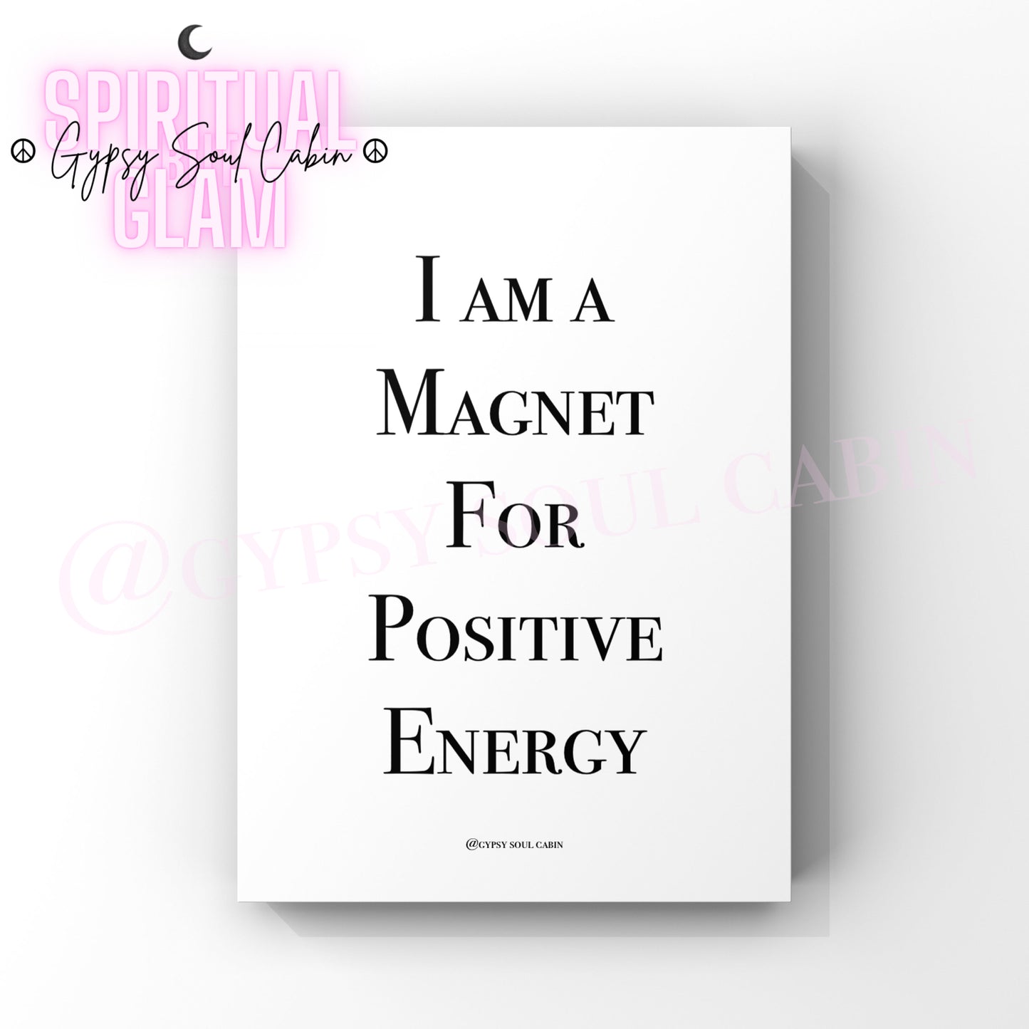 A white poster print with the text "I AM A MAGNET FOR POSITIVE ENERGY" in black writing.