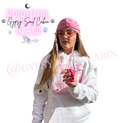 A pretty girl wearing a Gypsy Soul Cabin unique hoodie with pink accessories to match such as pink fashion glasses, pink fashion Y2T style rings and gypsy head wrap on a fresh white background.