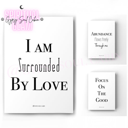 Set Of black and white quote prints with the text ‘I AM SURROUNDED BY LOVE’, ‘ABUNDANCE FLOWS FREELY THROUGH ME’ and 'FOCUS ON THE GOOD', ‘ on a white background, with a watermark that says 'Gypsy Soul Cabin'.