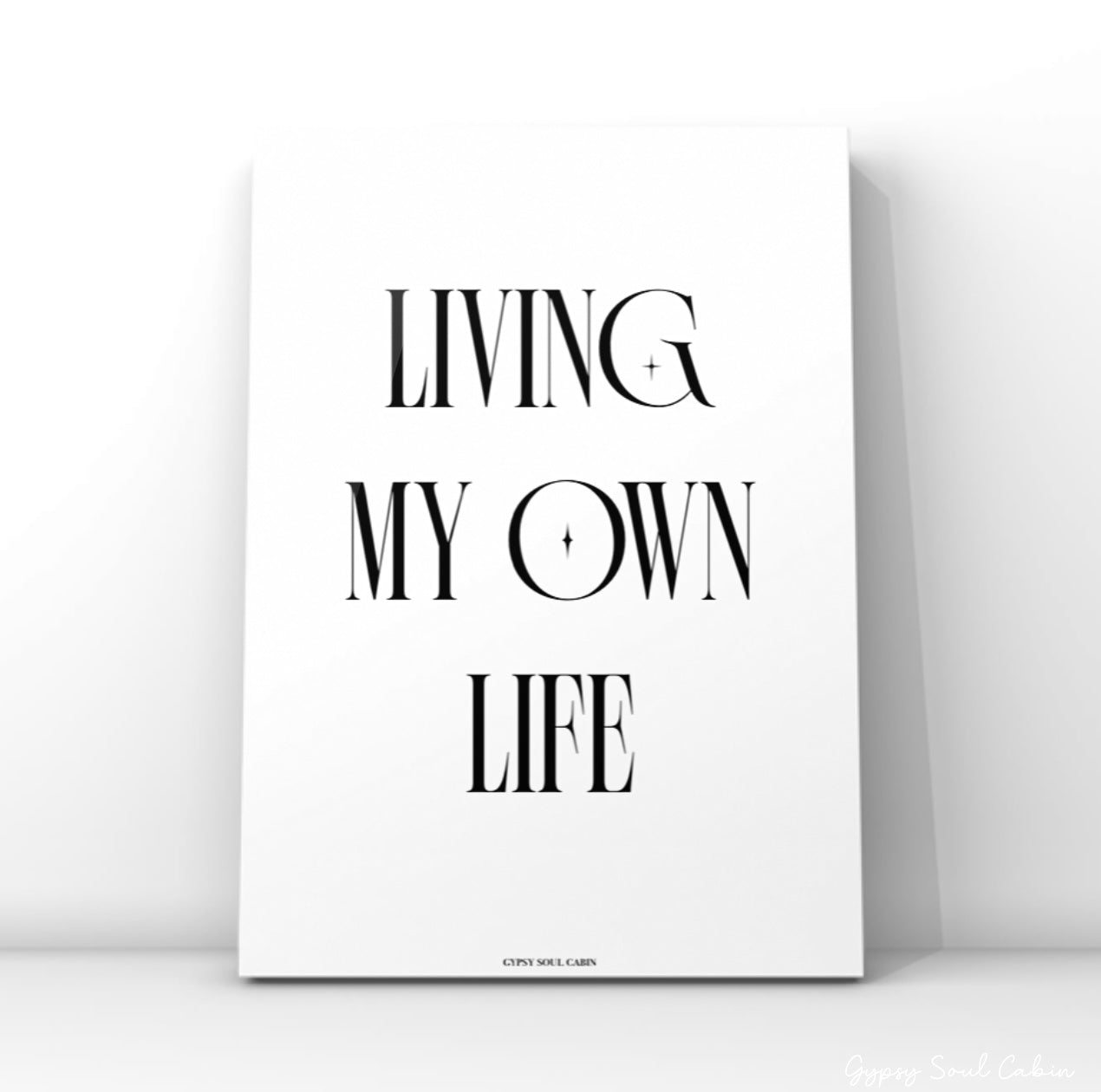 Minimalist black and white typography quote print featuring the text Living My Own Life with small star graphic elements inside the letters.