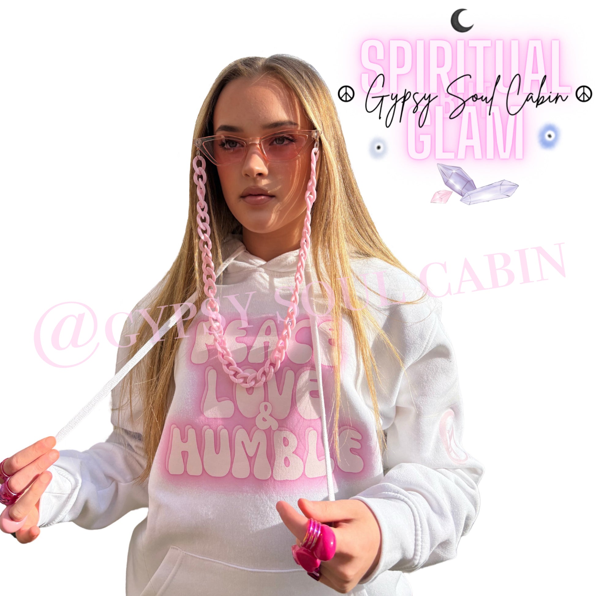 Model showcasing chunky, bright-pink statement rings on both hands while wearing a pink sunglasses chain lanyard and a white Peace Love Humble graphic hoodie by Gypsy Soul Cabin.