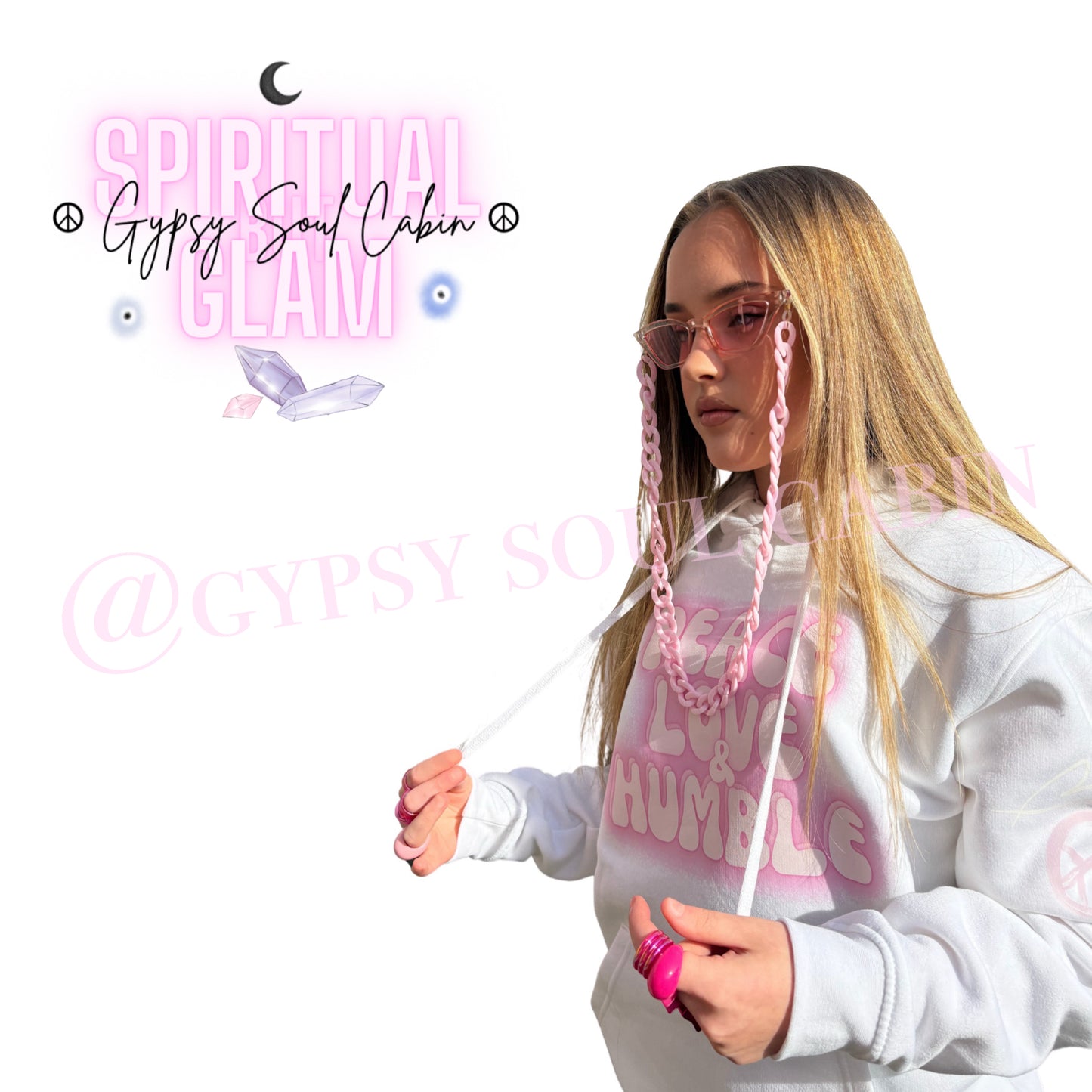 Side view profile of a model showing pink Y2K chunky rings worn on her thumb, paired with a pink sunglasses chain lanyard and a white Peace Love Humble graphic hoodie by Gypsy Soul Cabin.